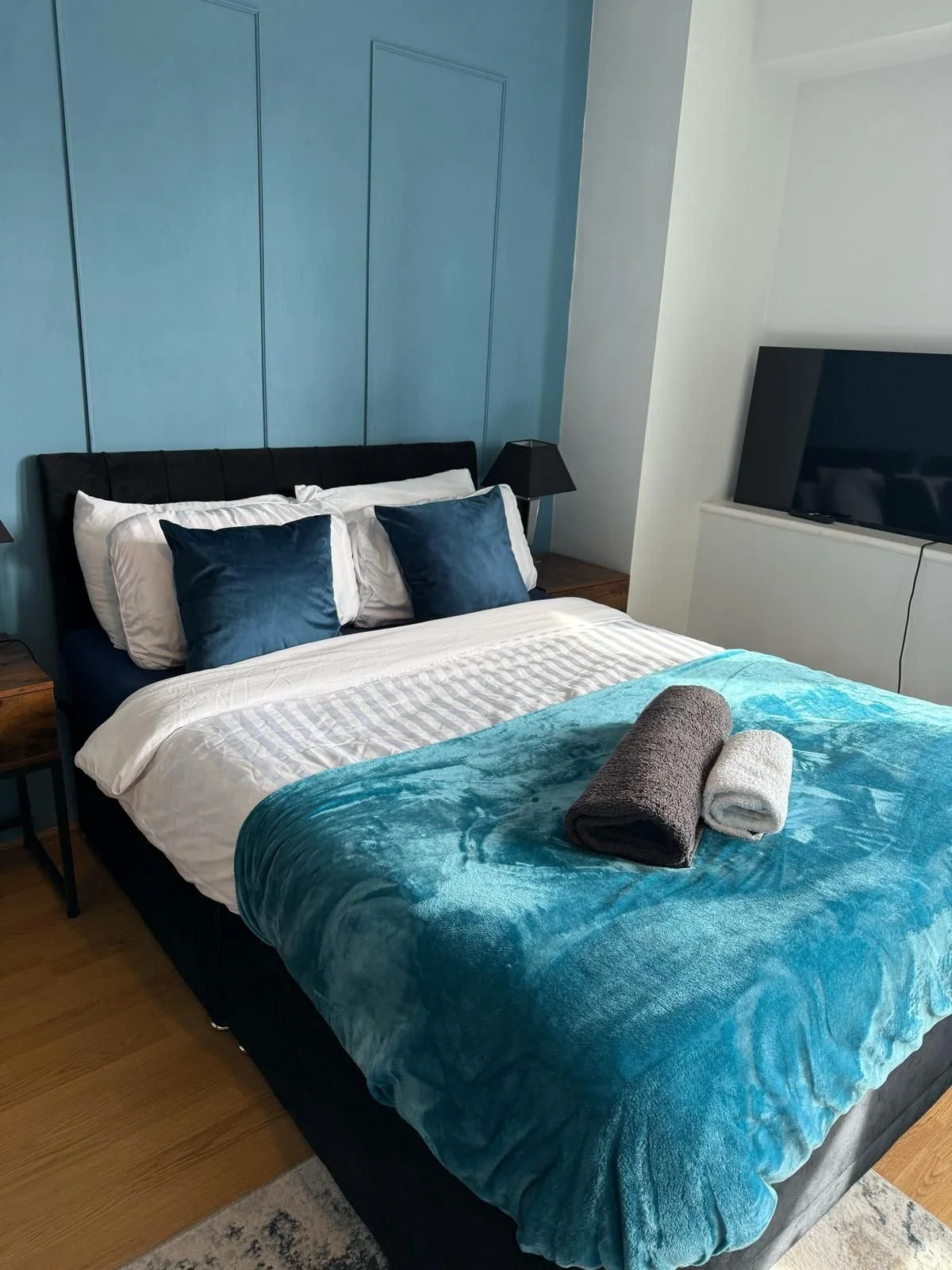 Freshly made bed with folded towels in a bedroom after cleaning