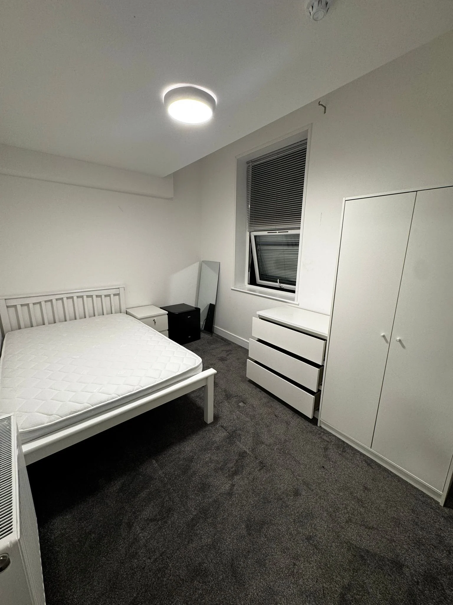 Bedroom after a deep clean, with clear carpet and wiped surfaces